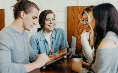Group of young people having a discussion around a laptop